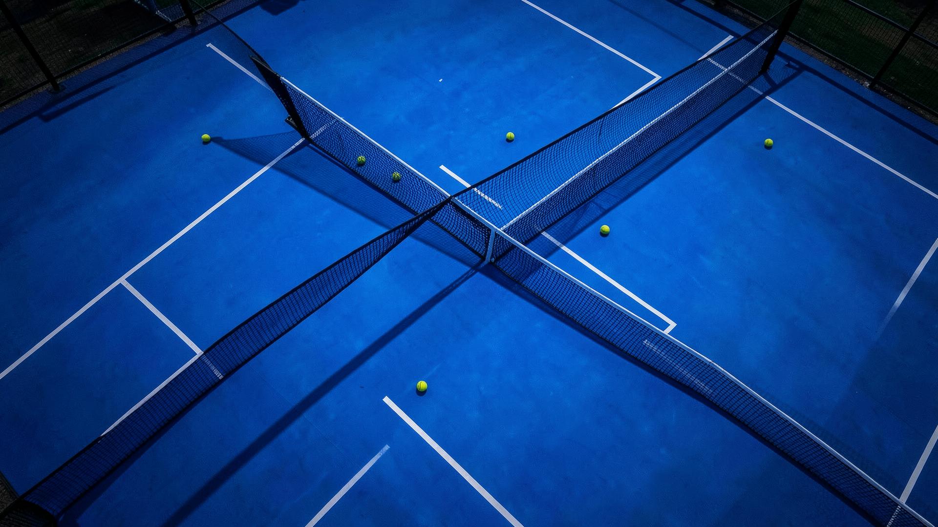 Aerial view of a blue padel court at dusk